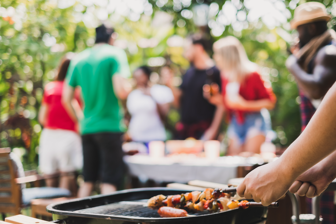 picture of a family gathering at a backyard BBQ, and grilling.