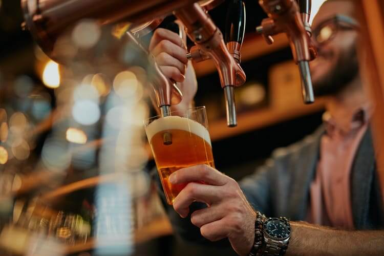 Barman pours beer