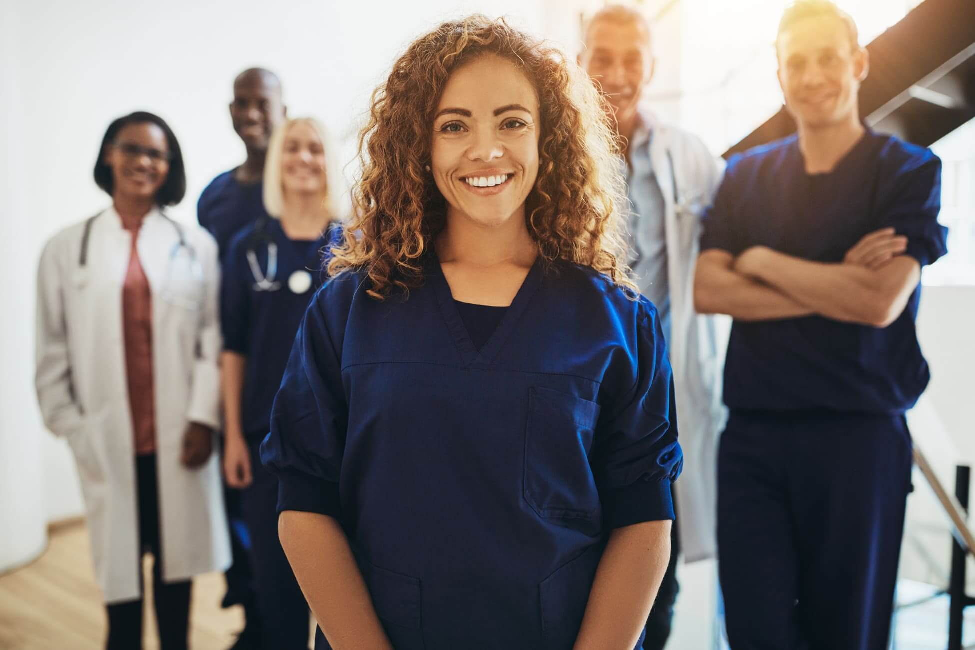 Smiling female doctor standing with medical colleagues in a hosp